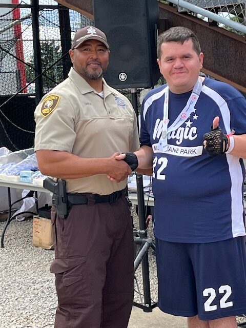 Special Olympics Ceremony participant shaking hands with Sheriff's Office member