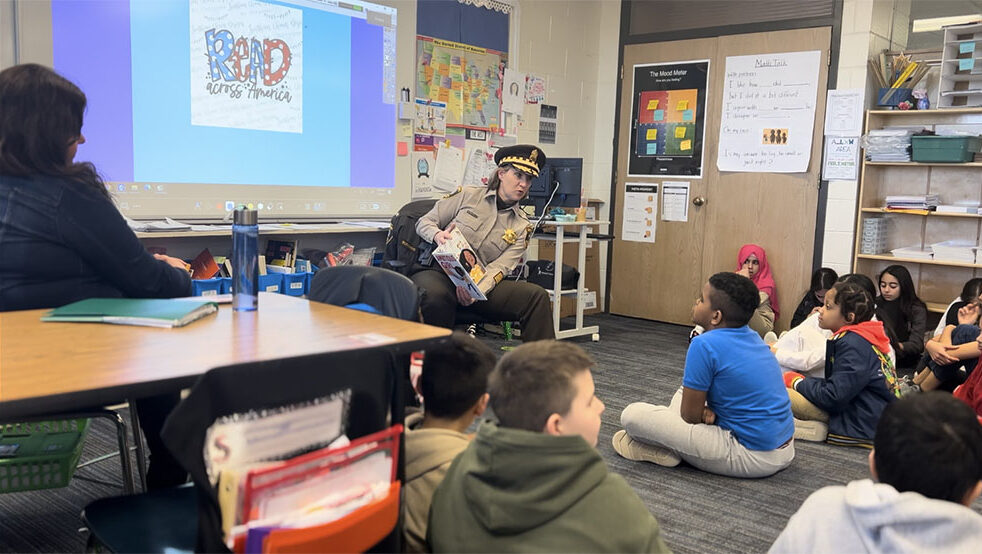Sheriff's Police Officer sitting and reading to a group of young individuals at the Read Across America event in Glenview
