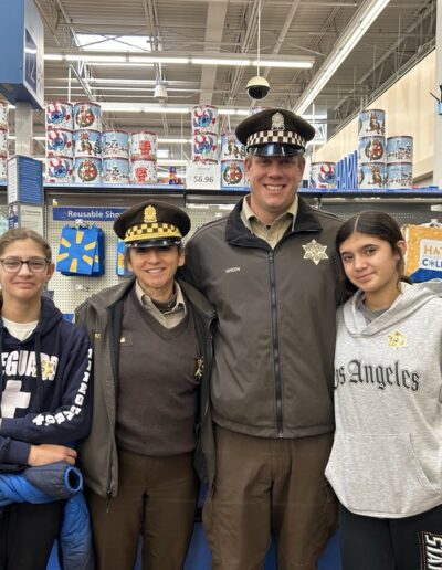 Sheriff's officers with two young participants in the Shop with a sheriff event