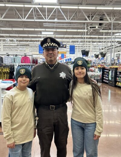 Sheriff's officer with two young participants in the Shop with a sheriff event